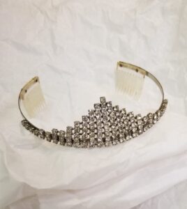 A pyramidal-shaped tiara displayed on white tissue paper.