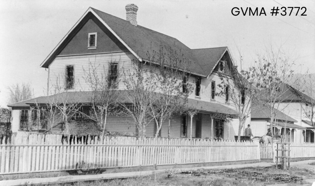 A black-and-white image of a house-like building with a covered verandah.