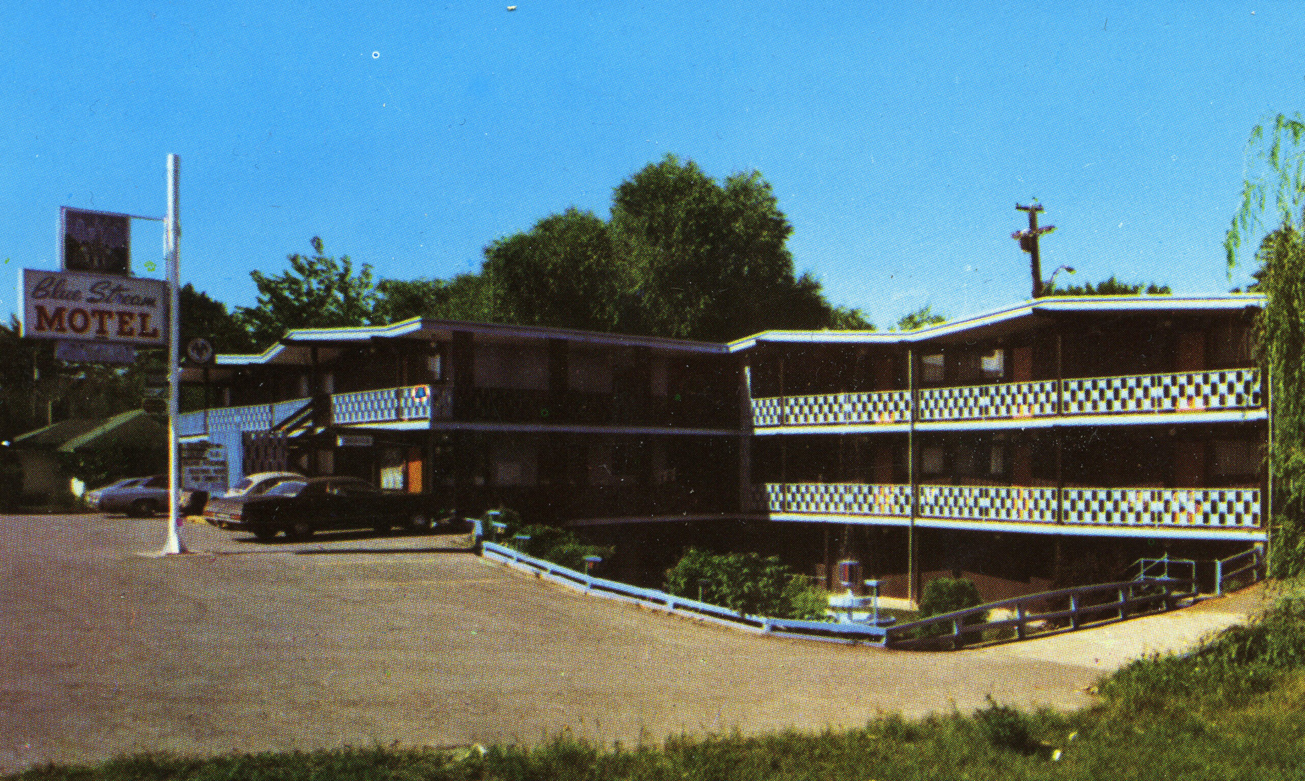 The blue stream motel with vintage cars parked in front